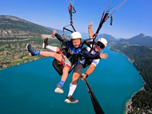 Un jeune passager découvre le parapente au cours du vol Enfant avec son pilote Flyeo dans le cadre magnifique du lac d'Annecy