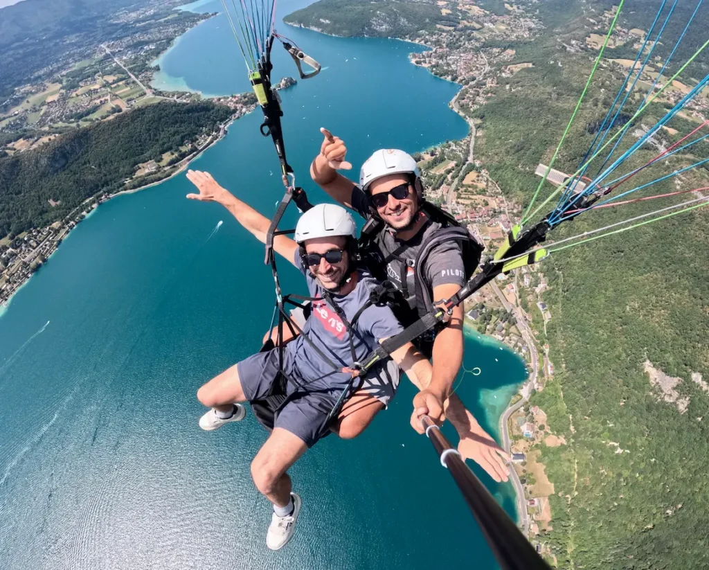Un passager vole comme un oiseau lors d'un vol en parapente à Annecy
