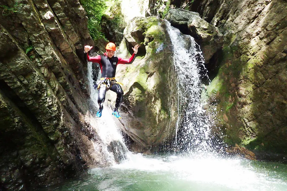 Une personne saute dans l'eau au cours d'une sortie canyoning avec Terreo, l'une des nombreuses activités que l'on peut faire autour de Doussard